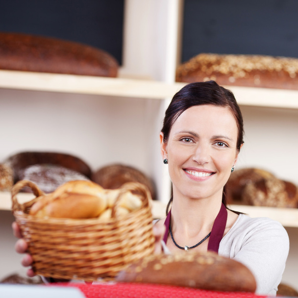 γυναίκα με ένα καλάθι με φρέσκα ψωμάκια - Φωτογραφία, εικόνα