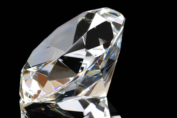 Horizontal image of a white diamond and its reflection with the table facing to the left upper corner on a black background. - Φωτογραφία, εικόνα