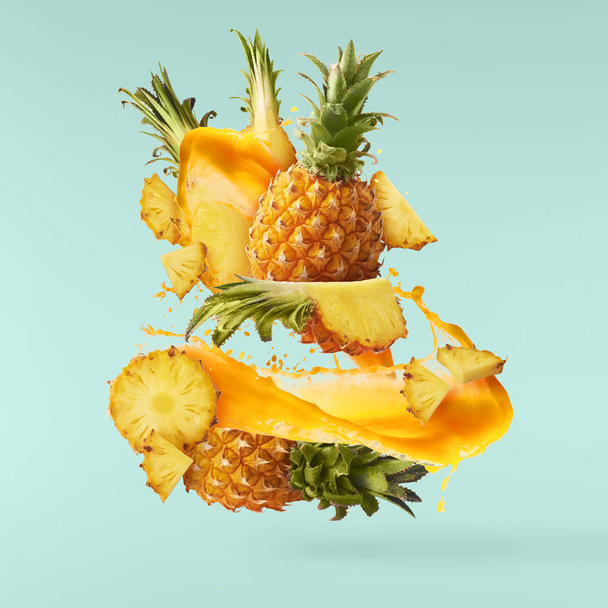 Flying in air fresh ripe whole and cut baby Pineapple with slice - Photo, Image