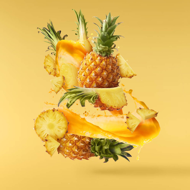 Flying in air fresh ripe whole and cut baby Pineapple with slice - Photo, Image