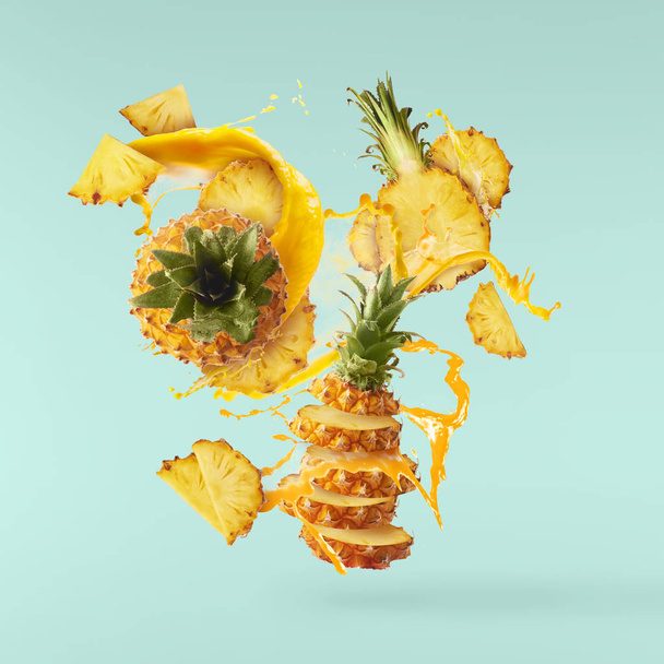 Vliegen in de lucht vers rijp hele en gesneden baby ananas met segment - Foto, afbeelding