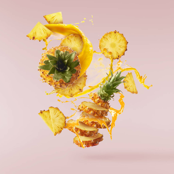 Volare in aria fresco maturo intero e tagliato ananas bambino con fetta
 - Foto, immagini