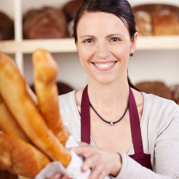Smiling saleslady in a bakery - Фото, изображение