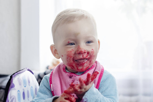 小さな子供は新鮮なベリーを食べ、彼の顔を塗った。非常に面白い画像. - 写真・画像