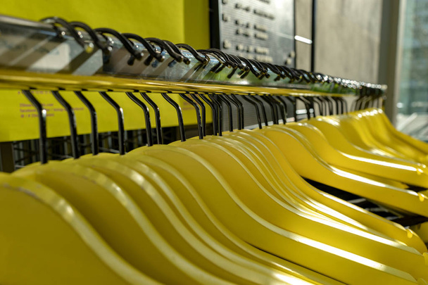 Желтые и другие вешалки для одежды на шкафу
 - Фото, изображение