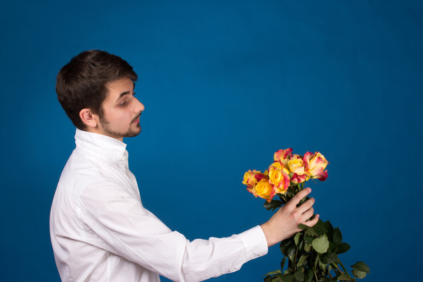 άνθρωπος με μπουκέτο με κόκκινα τριαντάφυλλα - Φωτογραφία, εικόνα