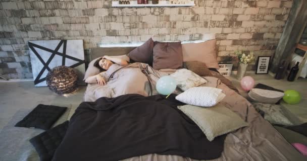 In the morning attractive lady waking up after a birthday party in her bed with a amazing urban design , she feeling good stretching body and smiling cute. - Materiał filmowy, wideo