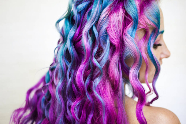 Ευχάριστα φωτεινά χρωματιστά μαλλιά, πολύχρωμο χρωματισμό σε μακριά μαλλιά. Το κομψό, σύγχρονο styling των μπούκλες. - Φωτογραφία, εικόνα