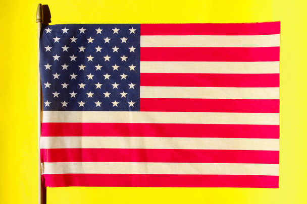 Shot Of The Flag Of The United States Of America. Cropped Shot Of American Flag Over Yellow Background. Independence Day USA.  - Фото, изображение