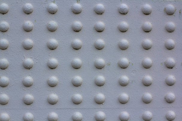 Textura de remaches de construcción metálica masiva. Fijación de la parte metálica del puente pintado de blanco. Array de círculos blancos convexos
. - Foto, imagen