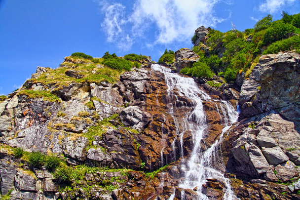 Скелястий водоспад в літній горі
 - Фото, зображення