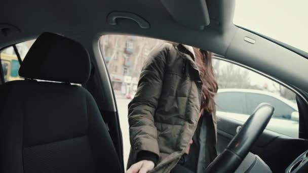 The girl sits behind the wheel of his car - Felvétel, videó