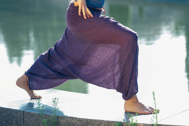 Attractive female practicing yoga asana outdoors - Photo, Image
