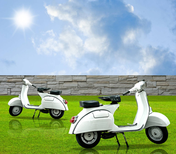 Retro white motorbike in the garden with nice sky - 写真・画像