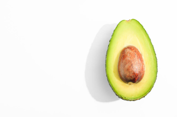 Rip cut avocado on white background, space for text - Foto, imagen