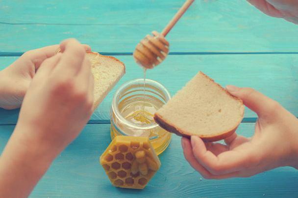 青い木製の背景に使用するための蜂蜜と蜂蜜のアクセサリー. - 写真・画像