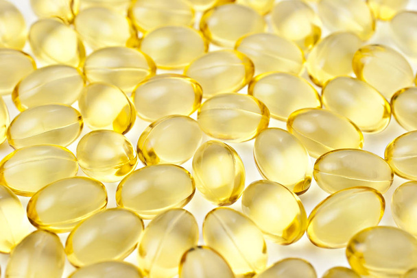 Nutritional supplement pills in warm colors and shallow depth of field. The yellow ones are vitamin E and cod liver oil. - Zdjęcie, obraz