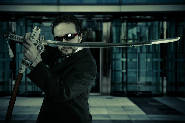 businessman with suit and Japanese sword, office building - Foto, Imagen