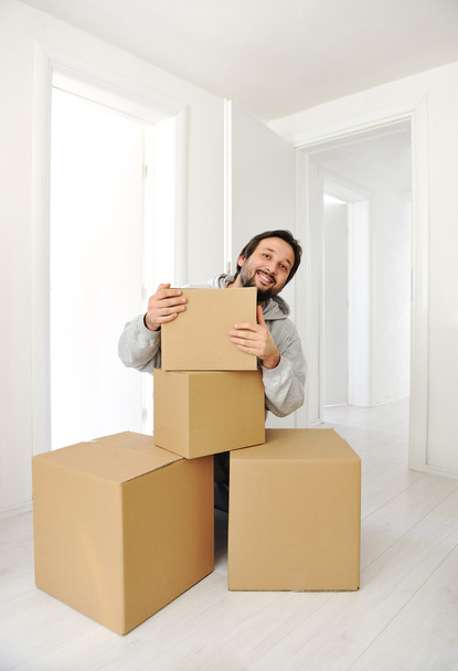 Man with boxes moving in new house - Foto, imagen