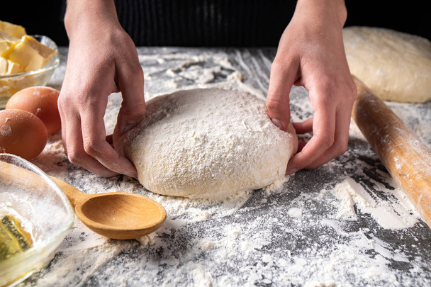 Making dough by female hands at bakery - Foto, Bild