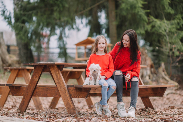 Mother and daughter playing with dog outdoors - Фото, зображення
