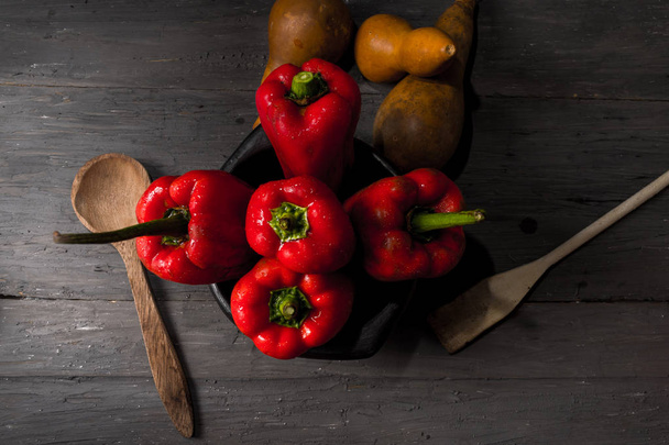 STILL LIFE OF RED PEPPERS ON A RUSTIC WOODEN TABLE - Fotografie, Obrázek