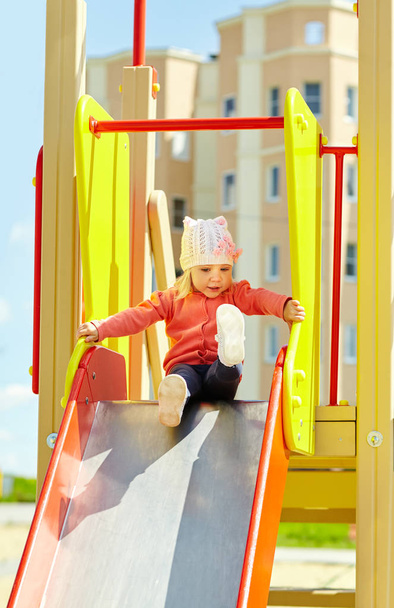 funny little girl on playground. child on slide - 写真・画像