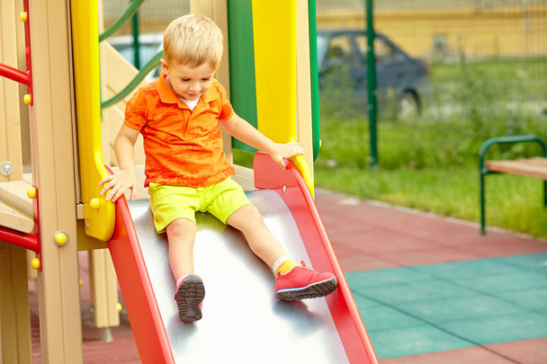 active little boy on slide on playground - Φωτογραφία, εικόνα