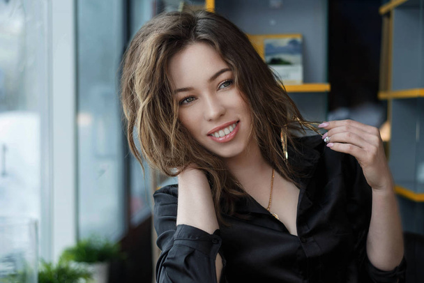 attractive and cheerful young woman smiling in cafe - Фото, зображення