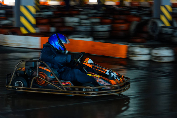 dynamischer Kart-Wettbewerb in Geschwindigkeit mit verschwommener Bewegung auf einer ausgestatteten Rennbahn - Foto, Bild