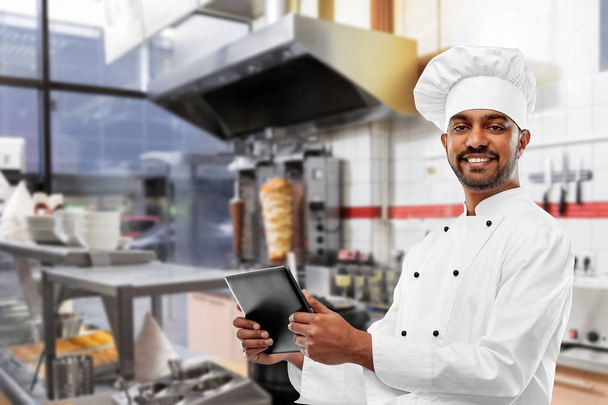 male indian chef with tablet pc at kebab shop - Foto, imagen