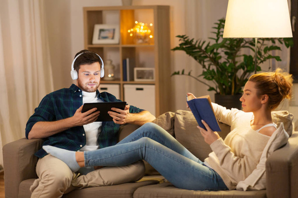 couple with tablet computer and book at home - Photo, image