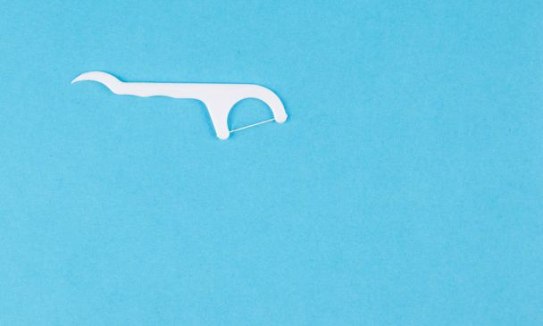 πλαστική οδοντογλυφίδα σε μπλε φόντο - Φωτογραφία, εικόνα