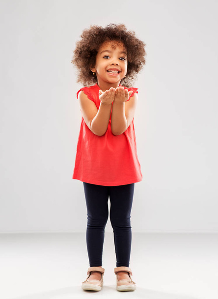 boldog afro-amerikai lány kezében valamit - Fotó, kép