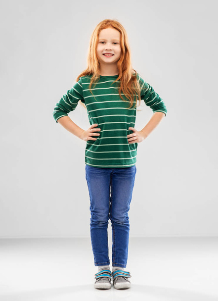 smiling red haired girl posing in striped shirt - Фото, изображение