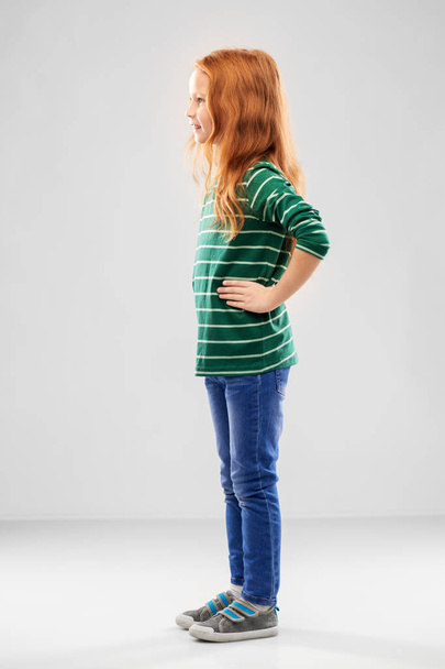 smiling red haired girl posing in striped shirt - 写真・画像