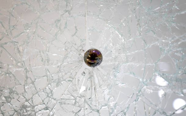 balle ronde noire coincée dans du verre cassé ou cassé
 - Photo, image