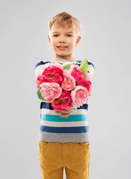 smiling boy with bunch of peony flowers - Фото, изображение