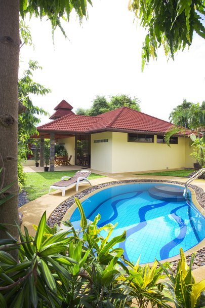 Вид на гарний літній будинок в тропічному середовищі
 - Фото, зображення