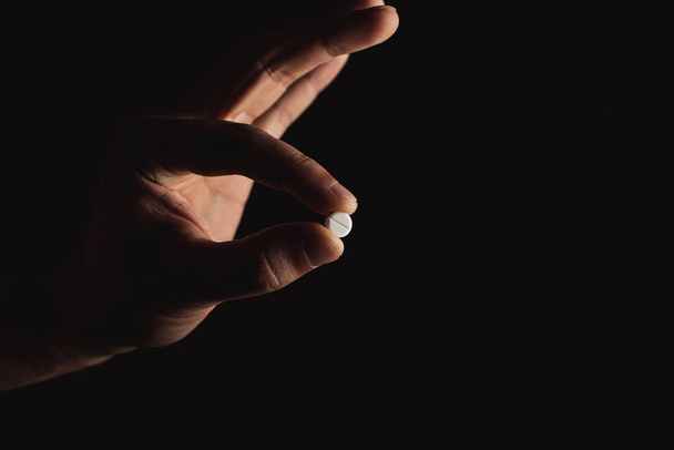 pills in hand on black background - Φωτογραφία, εικόνα