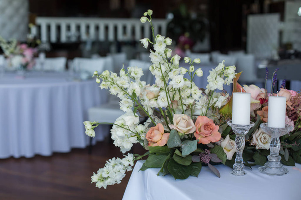 Tapahtuma valkoinen ravintola pöytä tarjoillaan ja koristeltu herkkä tuoreita kukkia
 - Valokuva, kuva