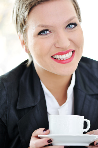 Portrait of cheerful businesswoman holding coffee cup - Foto, imagen