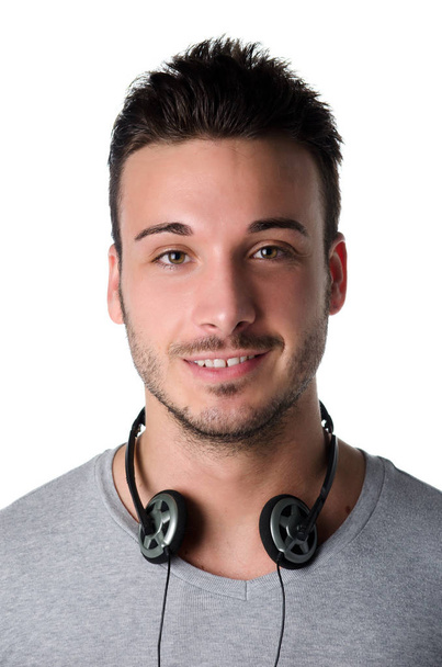 Handsome smiling young man with headphones around his neck, isolated on white - Photo, image