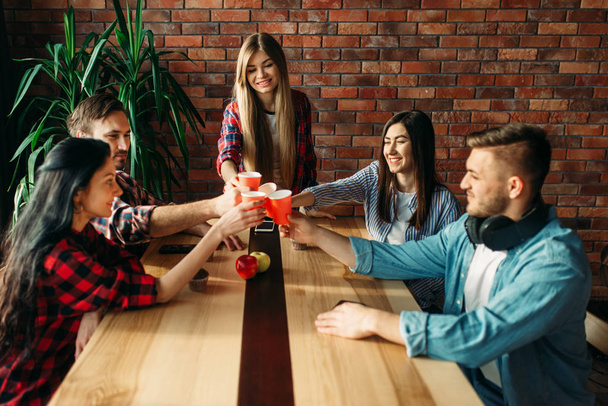 Group of students celebrate event. Youth with beverages at the table in college cafe, university  party - Фото, изображение