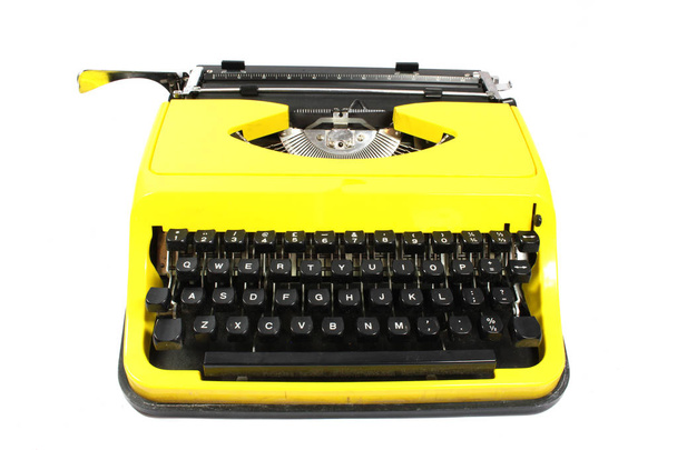 Retro keltainen kirjoituskone valkoisella taustalla
 - Valokuva, kuva