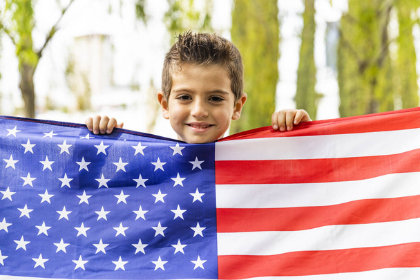 Lapsi näyttää Yhdysvaltain lipun 4. heinäkuuta
 - Valokuva, kuva