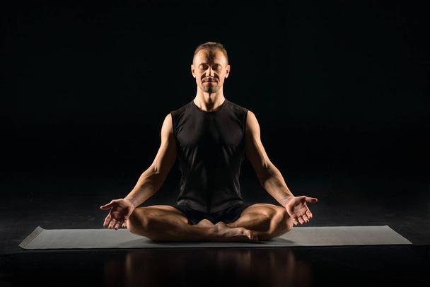 Man Performing Sukhasana Sitting On Yoga Mat ロイヤリティフリー写真 画像素材