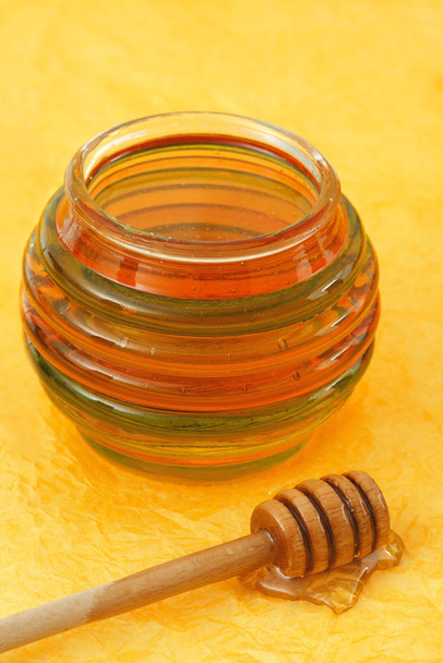 jar of fresh honey with wood stick - Fotoğraf, Görsel