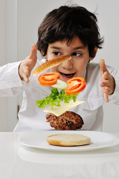 Little boy with hamburger ingredients in hands - Фото, зображення