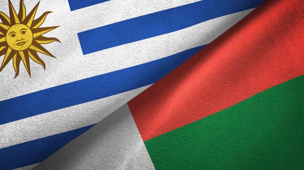 Uruguay a Madagaskar dvě vlajky textilní tkaniny, textura textilií - Fotografie, Obrázek